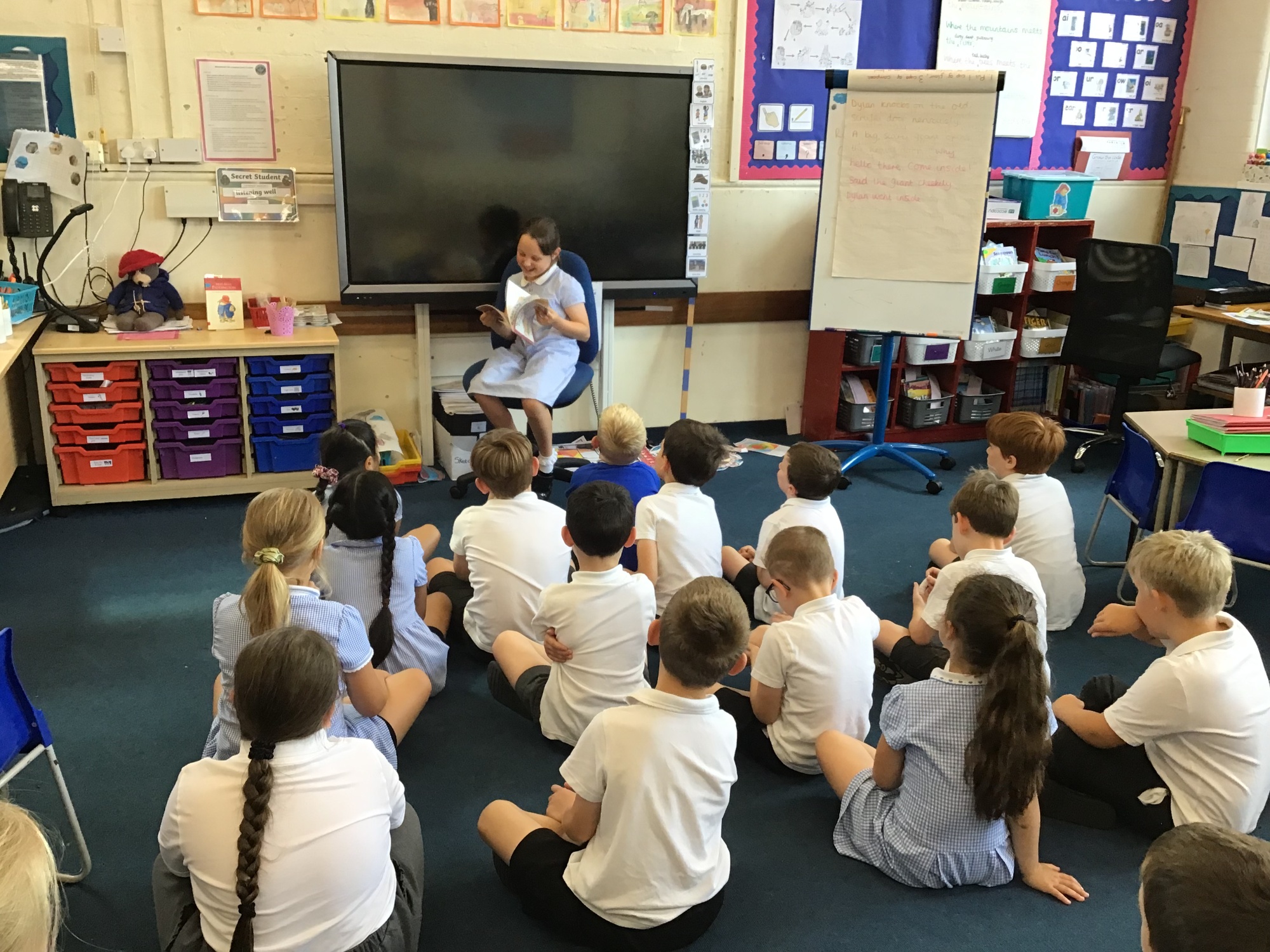Child reading book aloud to class
