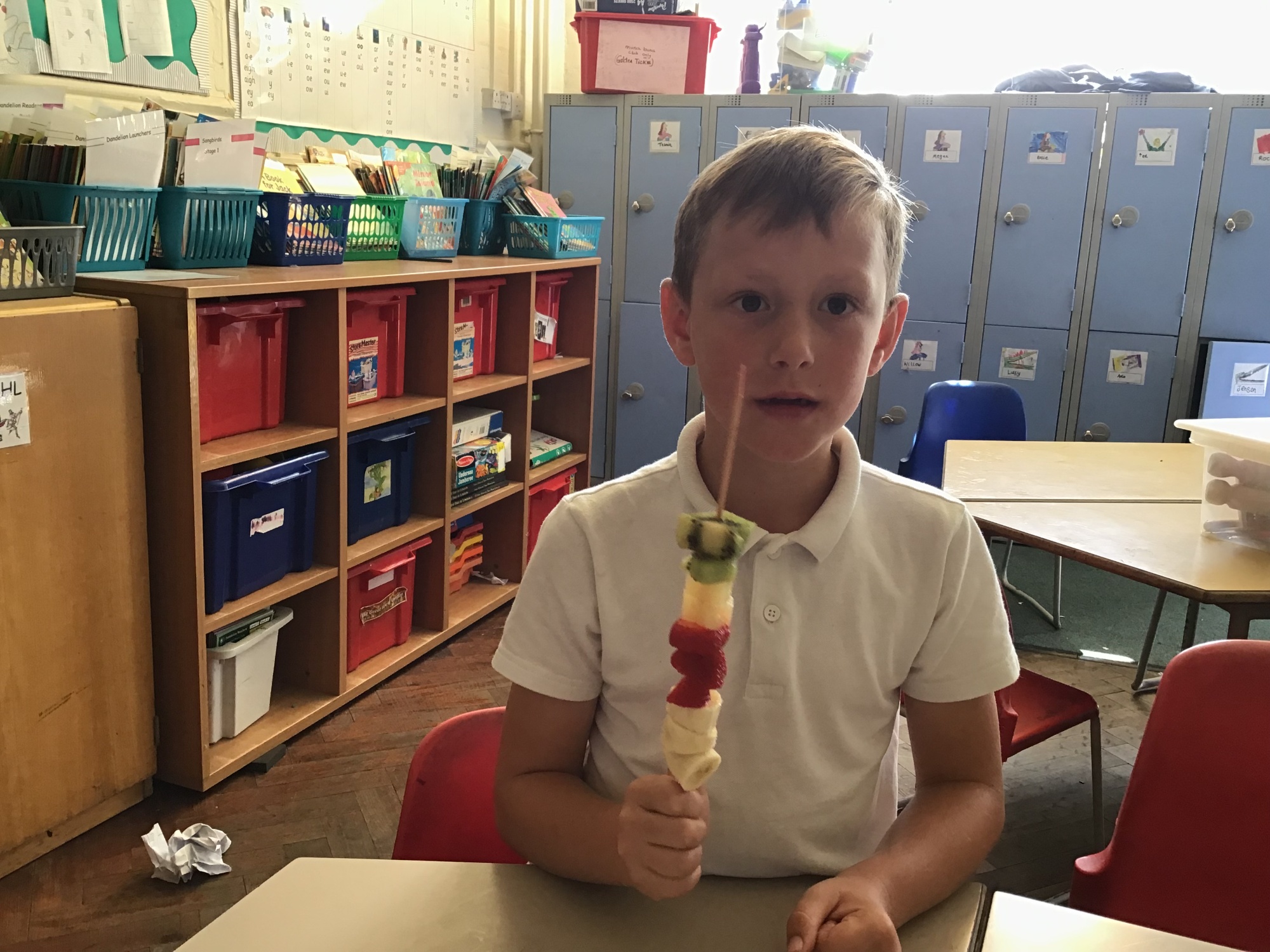 Child holding a fruit kebab